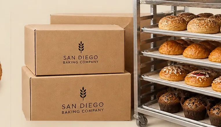 Bakery boxes stacked beside a rack of bagels, brioche and muffins
